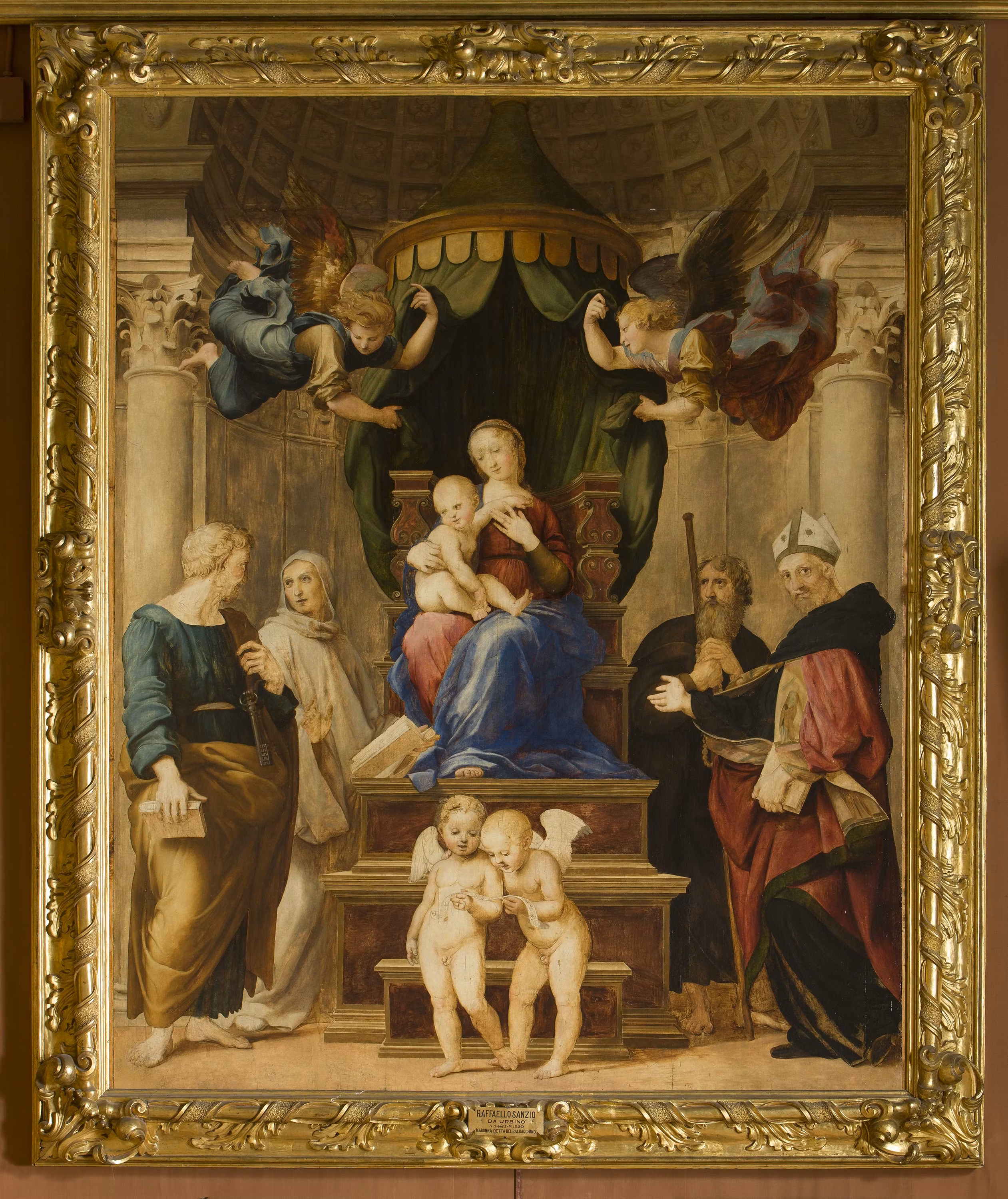 Un dipinto rinascimentale raffigura la Madonna col Bambino, circondata da angeli e santi, incorniciata in una cornice dorata intricata.