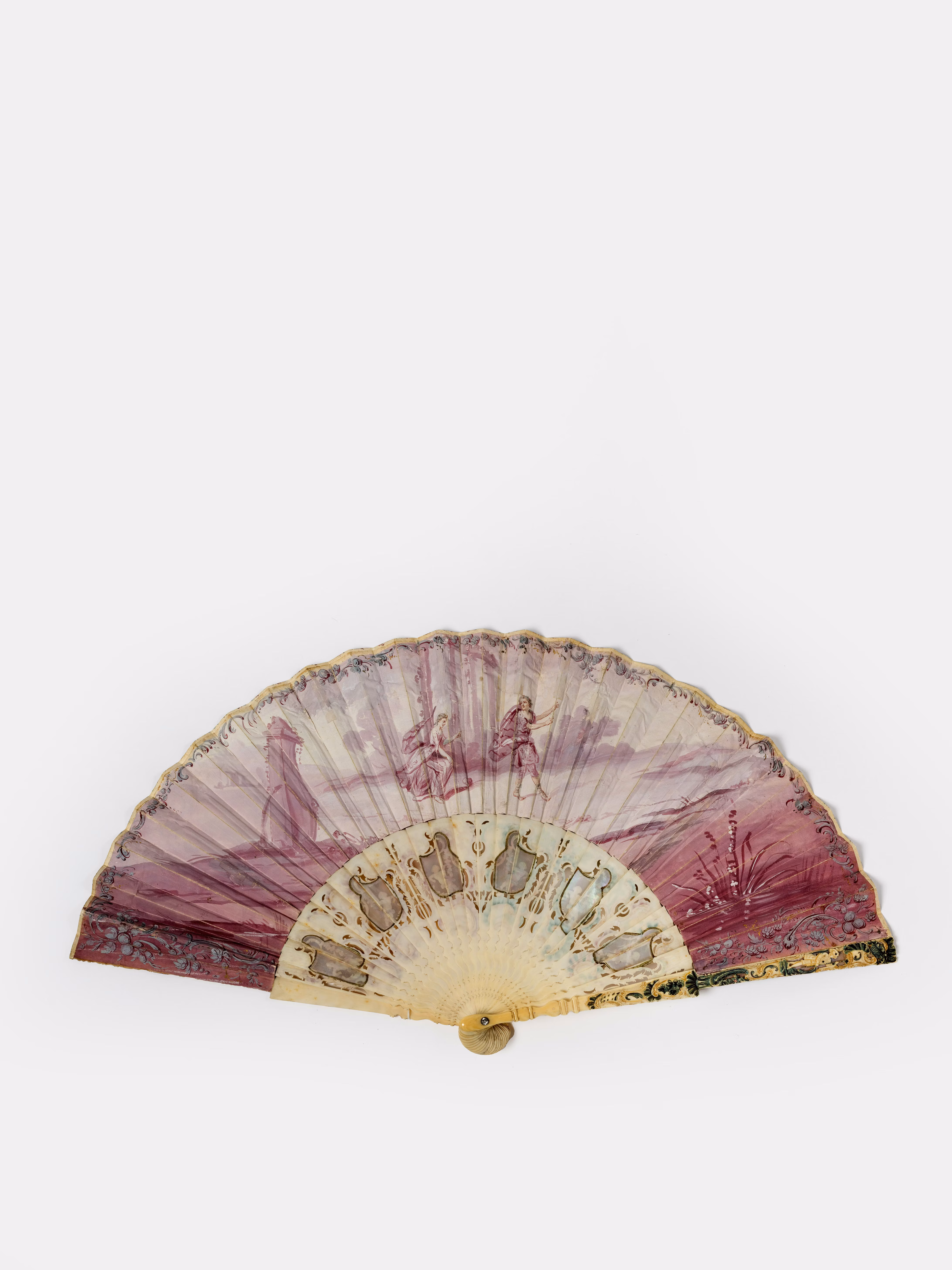 Ventaglio decorativo con trama floreale, realizzato con tela semitrasparente nei toni del viola e beige, dai motivi classici e accenti dorati sulla base, ideale per aggiungere un tocco elegante a qualsiasi ambiente.