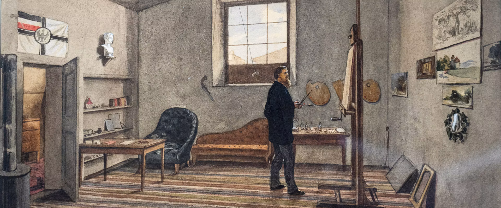 A man stands in a spacious artist's studio, holding a paintbrush in front of an easel, surrounded by various artworks, a comfortable chaise lounge, and bookshelves in a warmly lit room with a striped rug and a large window filtering natural light.
